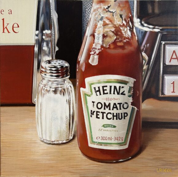 Una bottiglietta di ketchup marca Heinz in primo piano su un tavolo